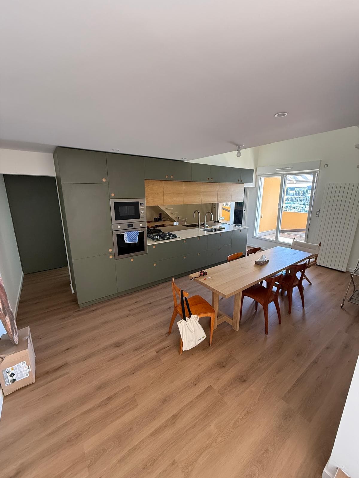 La cuisine ouverte, façades vert olive et chêne
