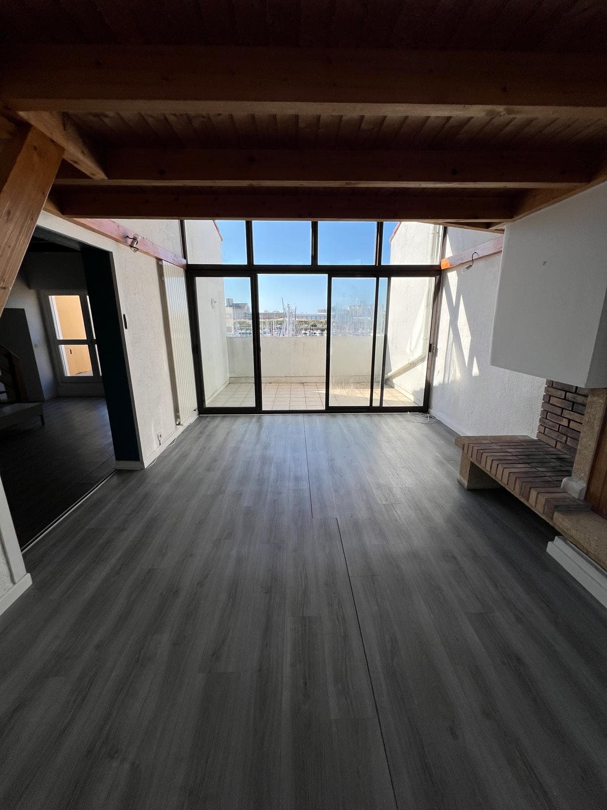 Le séjour vers la terrasse, avec le port en fond